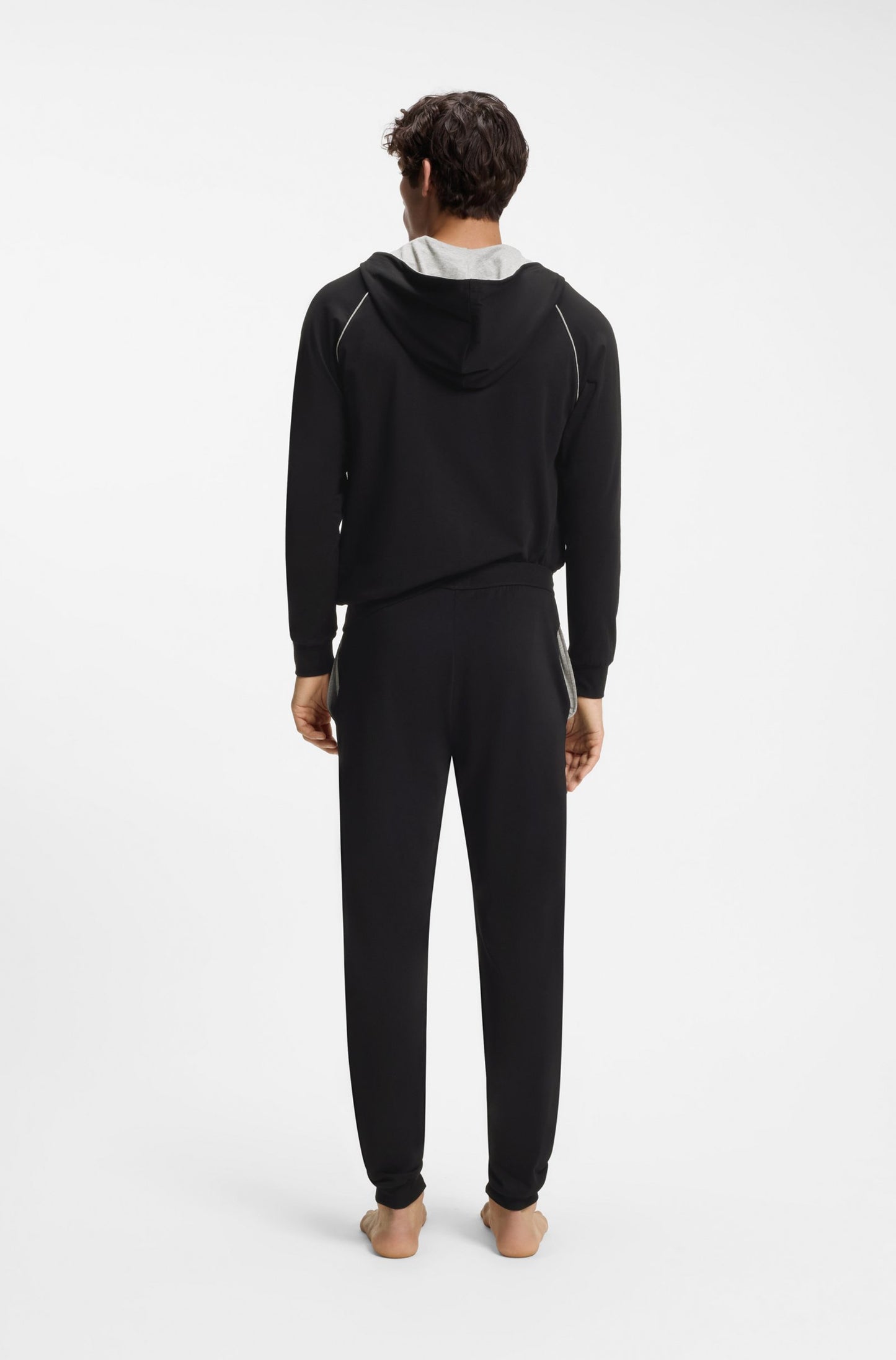 Person wearing a black tracksuit on a white background