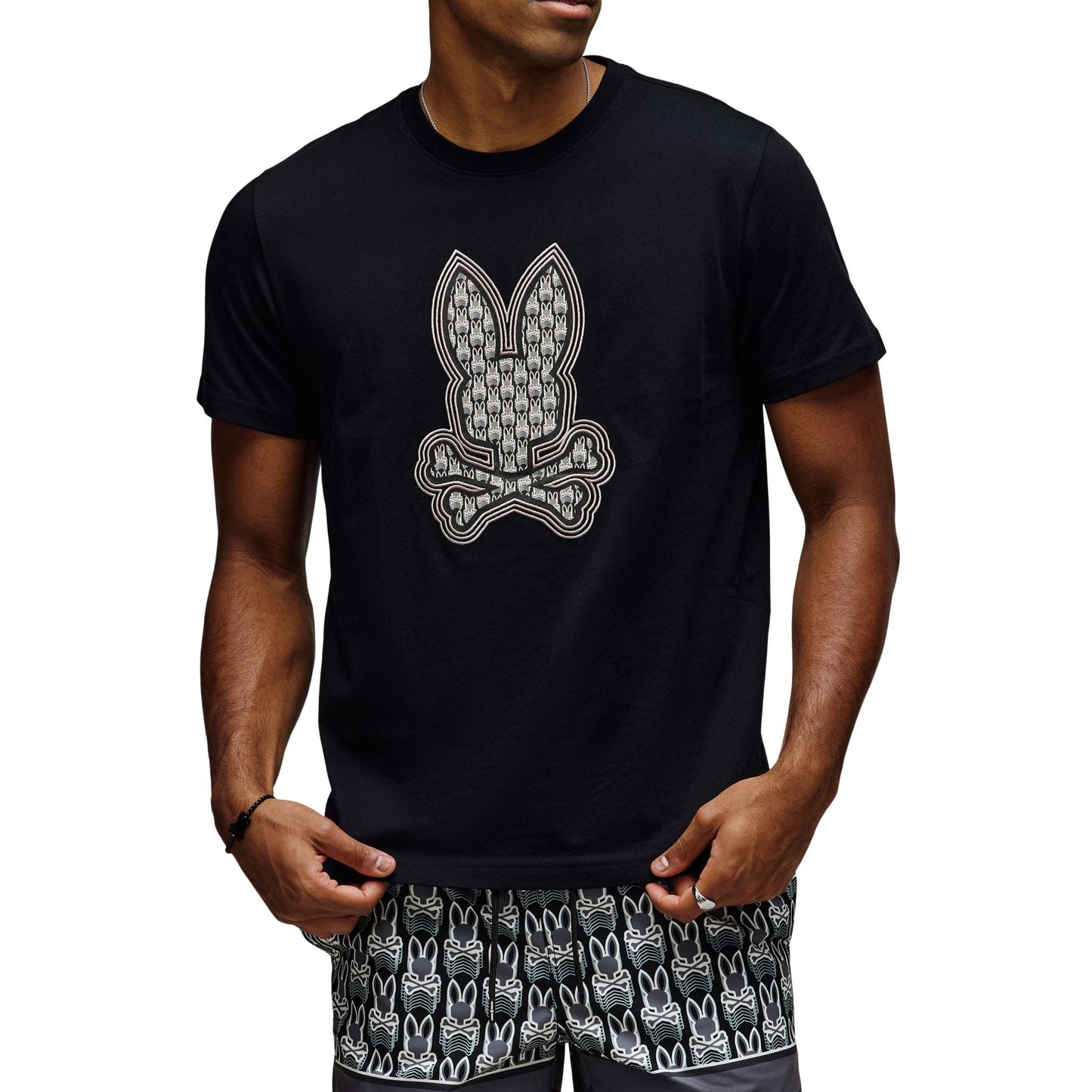 Man wearing a black t-shirt with a graphic design and matching shorts on a white background