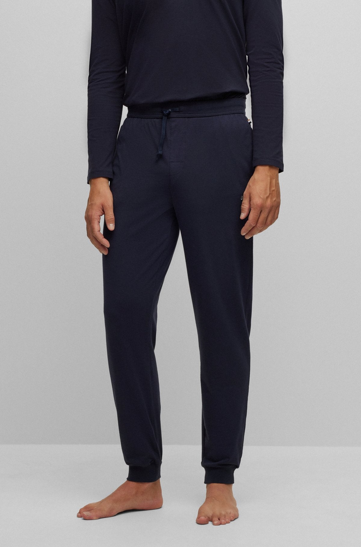 Person wearing navy blue pajama set on a white background