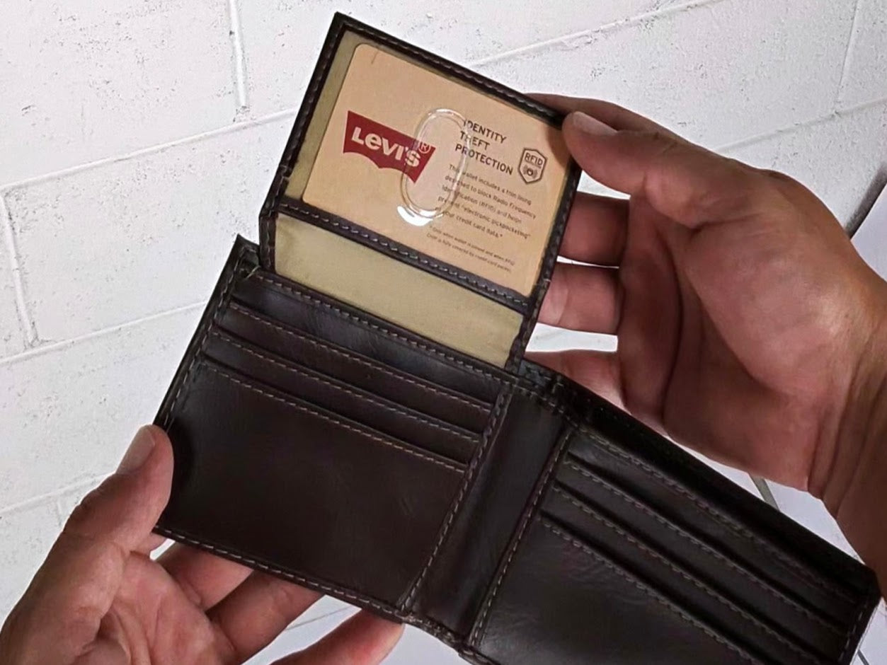 Brown leather wallet with a Levi's card on a white tiled floor background