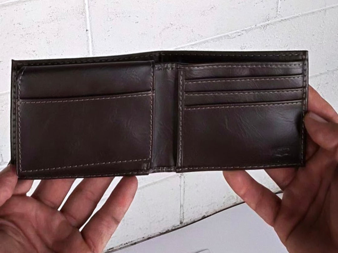 Brown leather wallet held open by hands on a light gray background