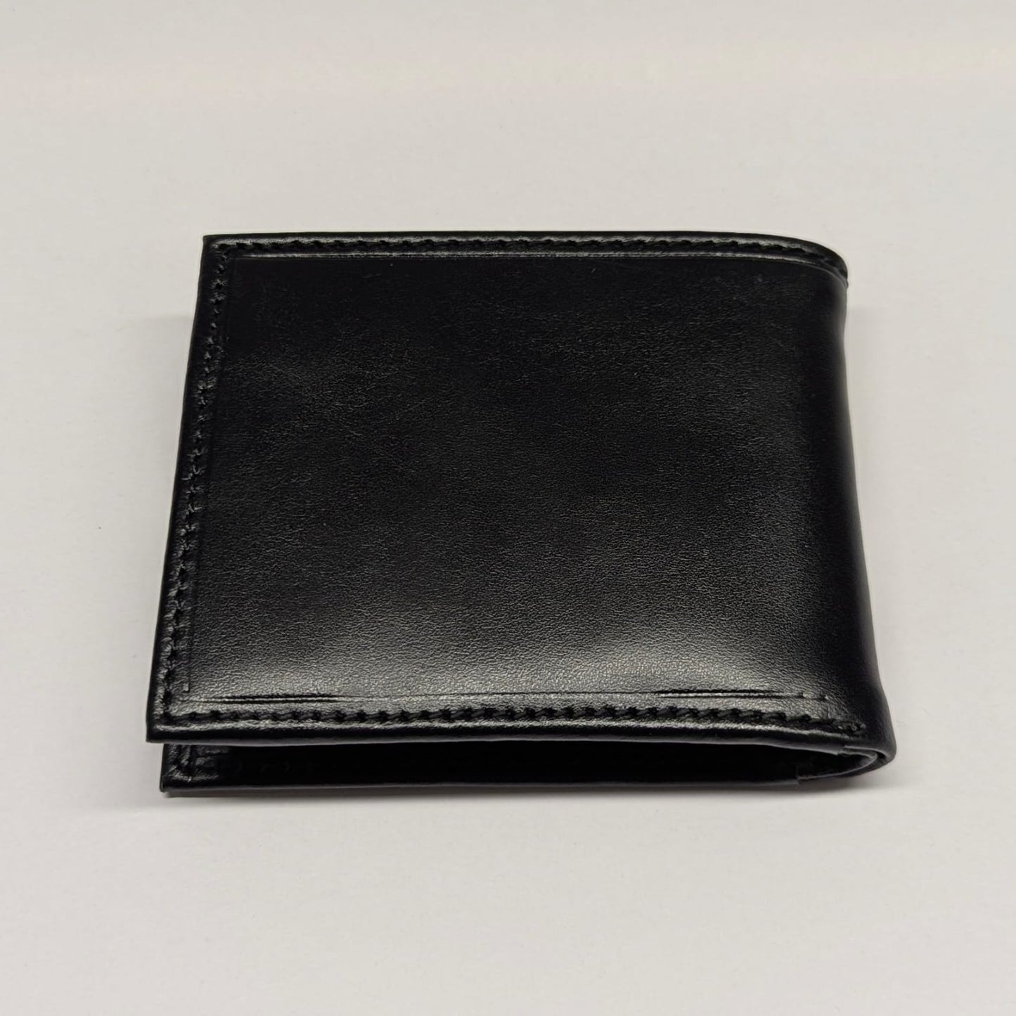 Black leather wallet on a light gray background