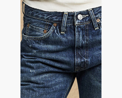 Close-up of blue jeans with a beige background