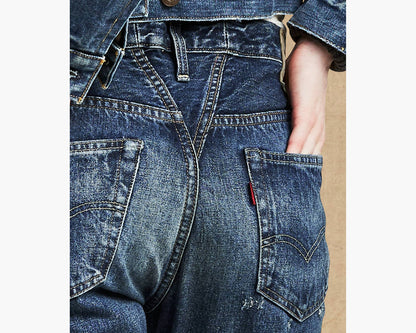 Close-up of blue denim jeans with a brand logo on a white background