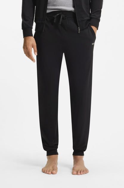 Person wearing black jogger pants on a white background