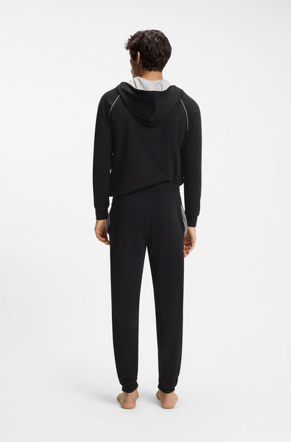 Person wearing a black tracksuit on a white background