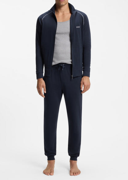 Man wearing navy tracksuit with gray shirt on a white background