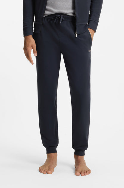 Person wearing navy blue jogger pants on a white background