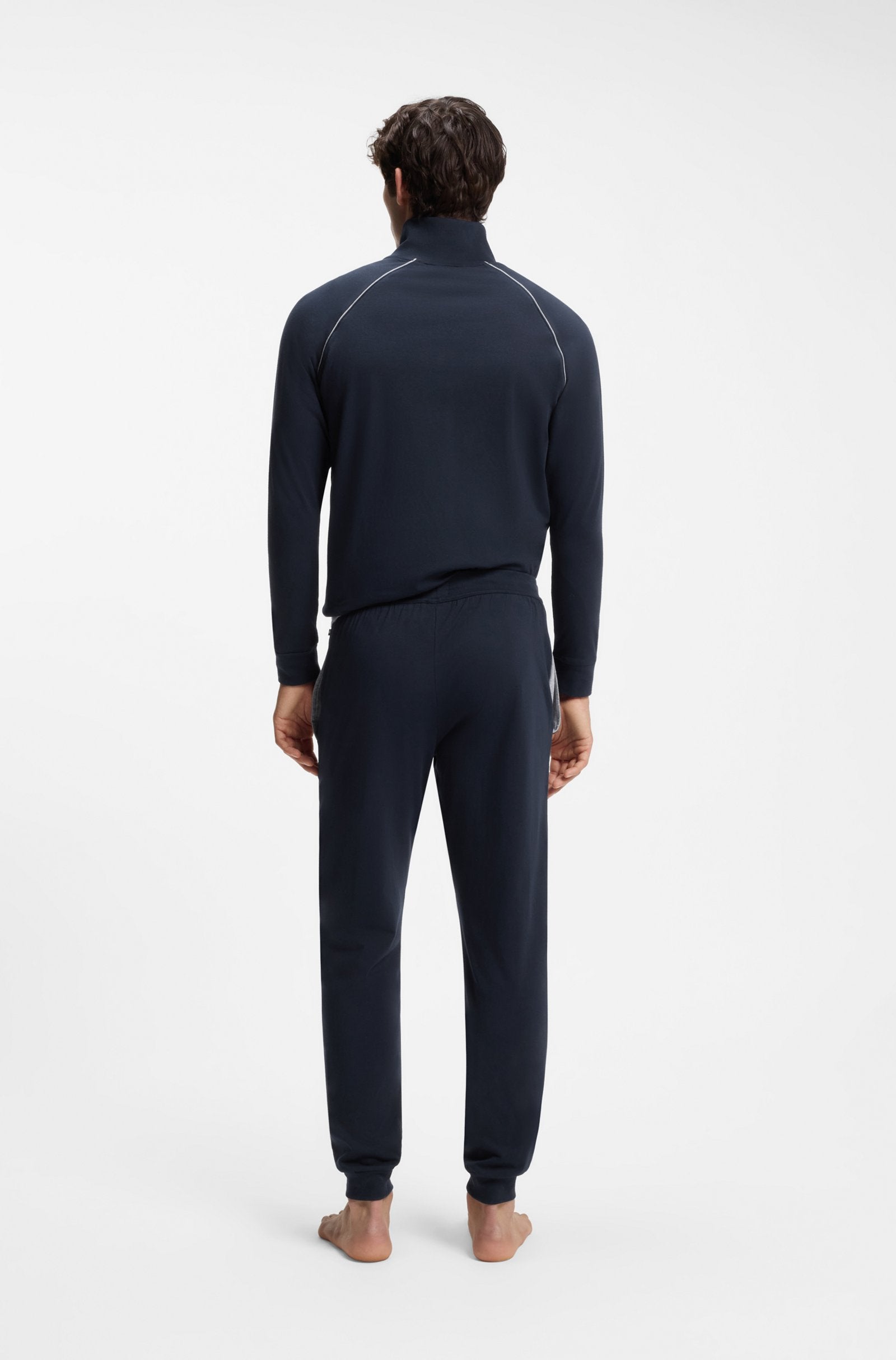Person wearing a navy blue tracksuit on a white background