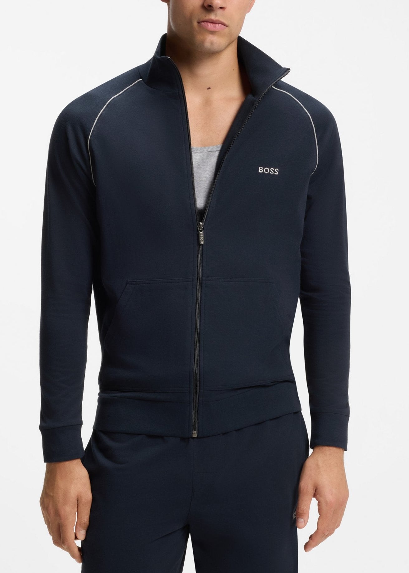 Man wearing a navy tracksuit with a brand logo on a white background