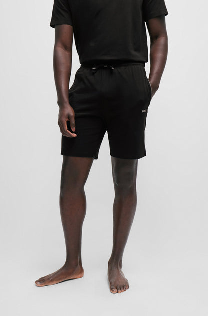 Person wearing black shorts and a black shirt on a white background
