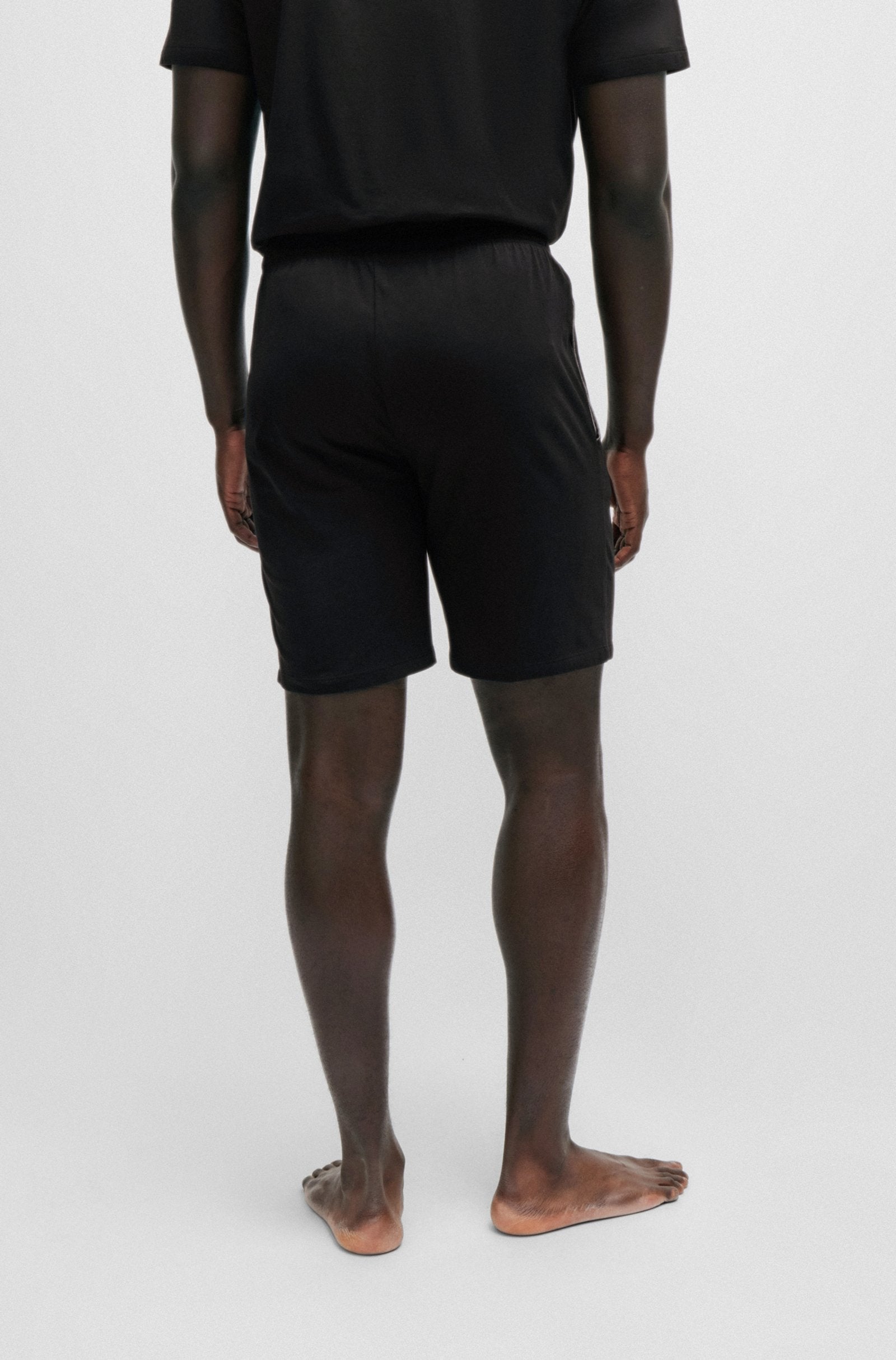 Person wearing black shorts and a black shirt on a white background