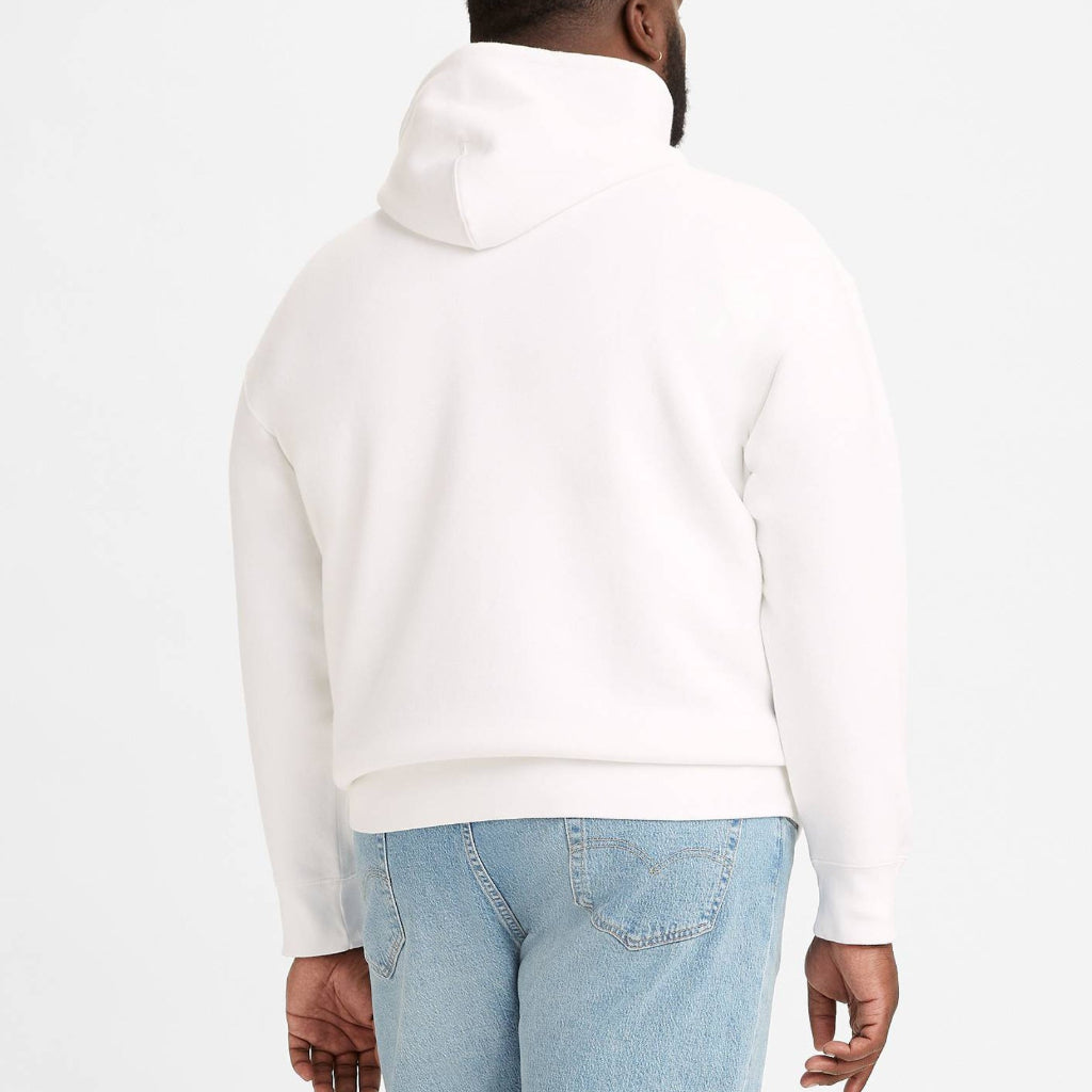 Person wearing a white hoodie and light blue jeans on a white background