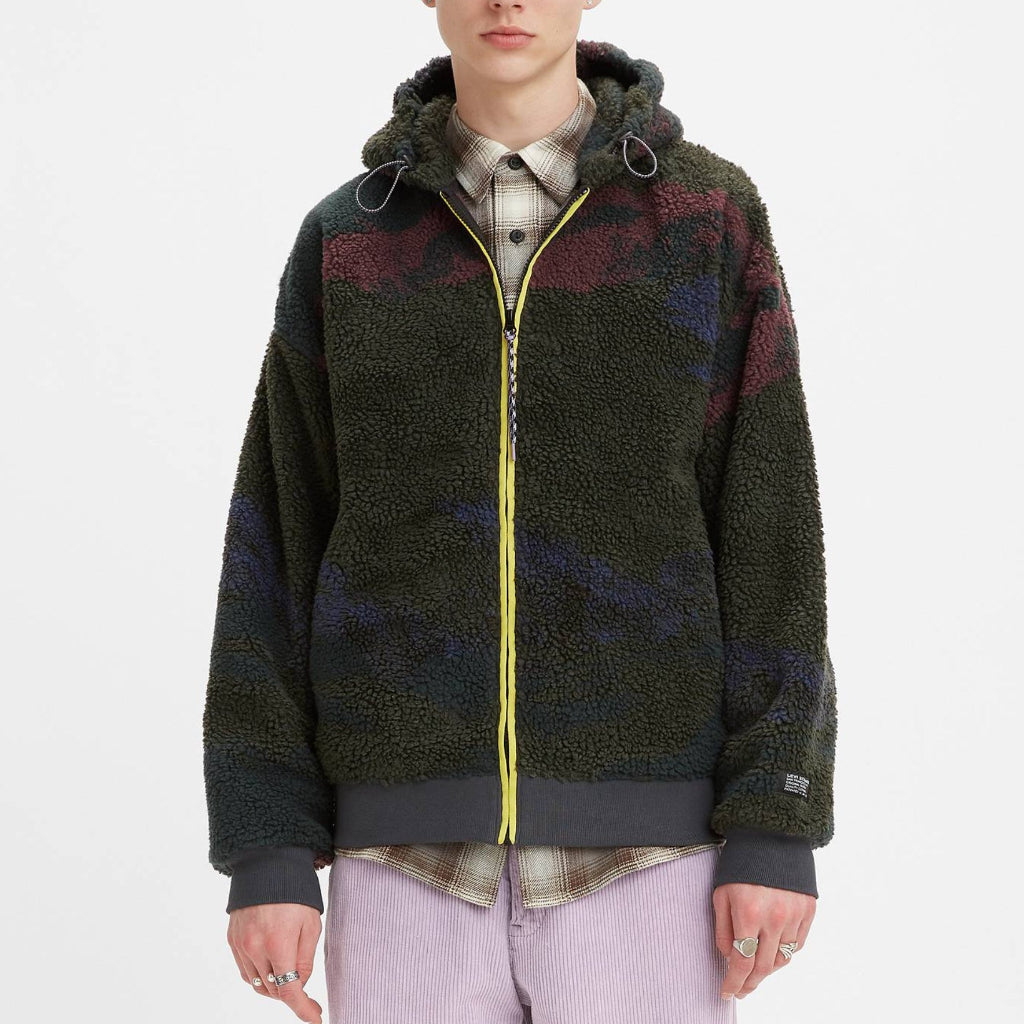 Person wearing a patterned jacket with a hood on a white background
