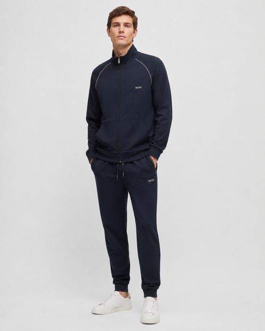 Man wearing a navy tracksuit with a white background