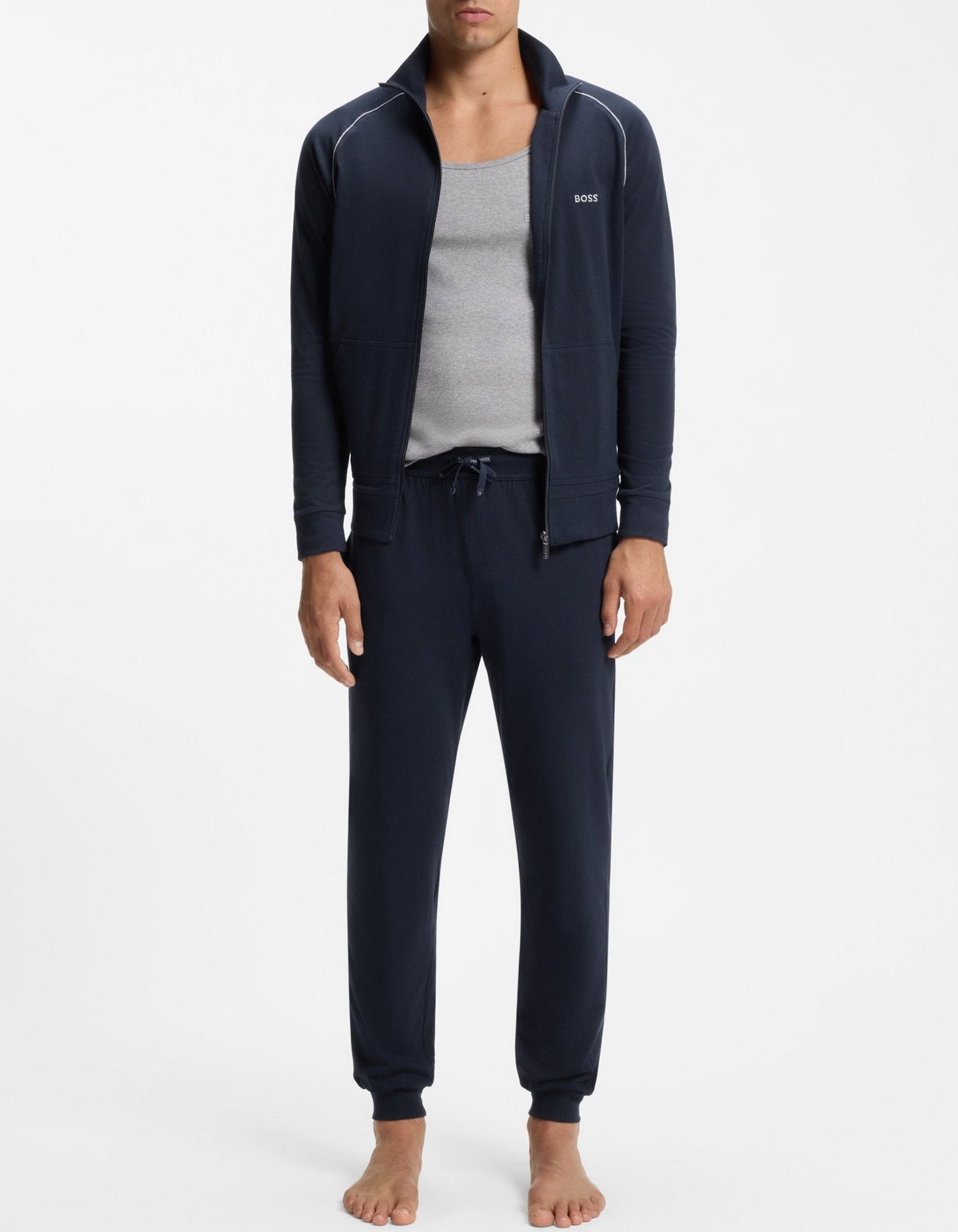Man wearing navy tracksuit with gray shirt on a white background