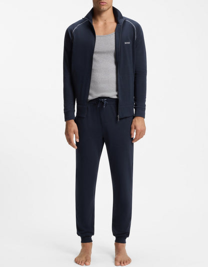 Man wearing navy tracksuit with gray shirt on a white background