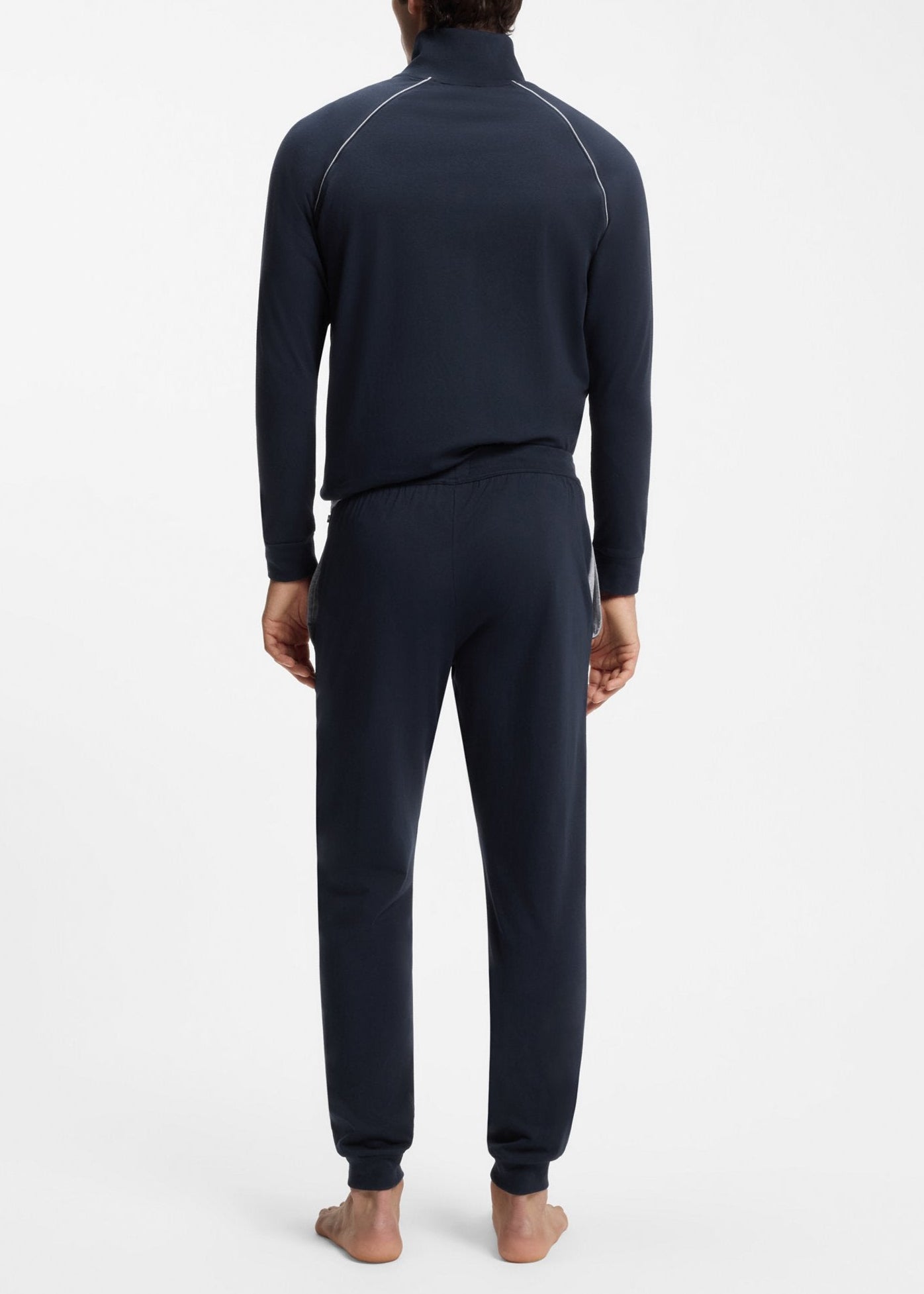 Person wearing a navy blue tracksuit on a white background