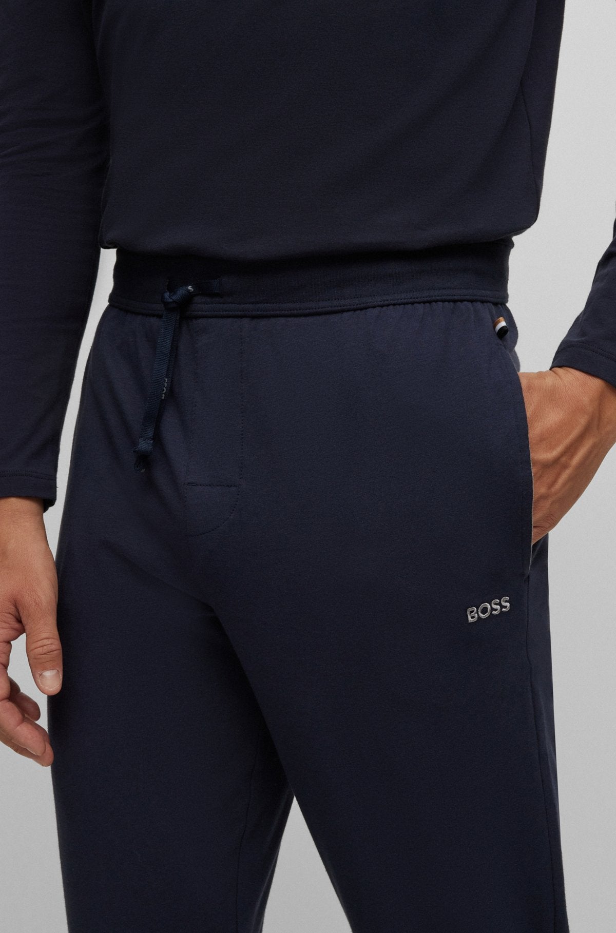Navy tracksuit with 'BOSS' branding on a gray background