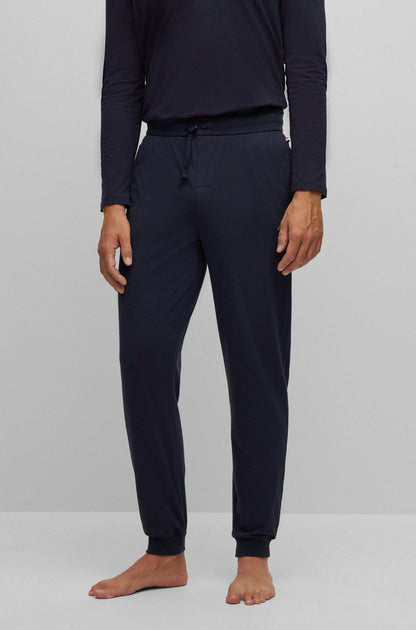 Person wearing navy blue pajama set on a white background